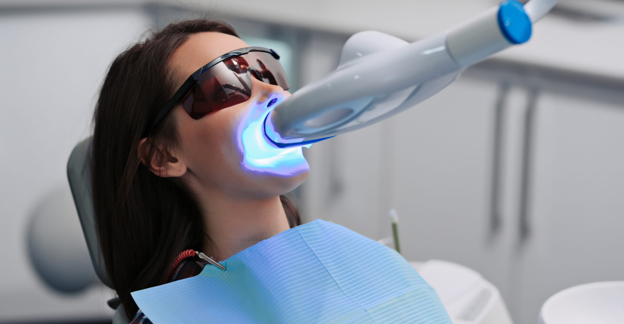 Woman receiving a teeth whitening treatment in a dentist office