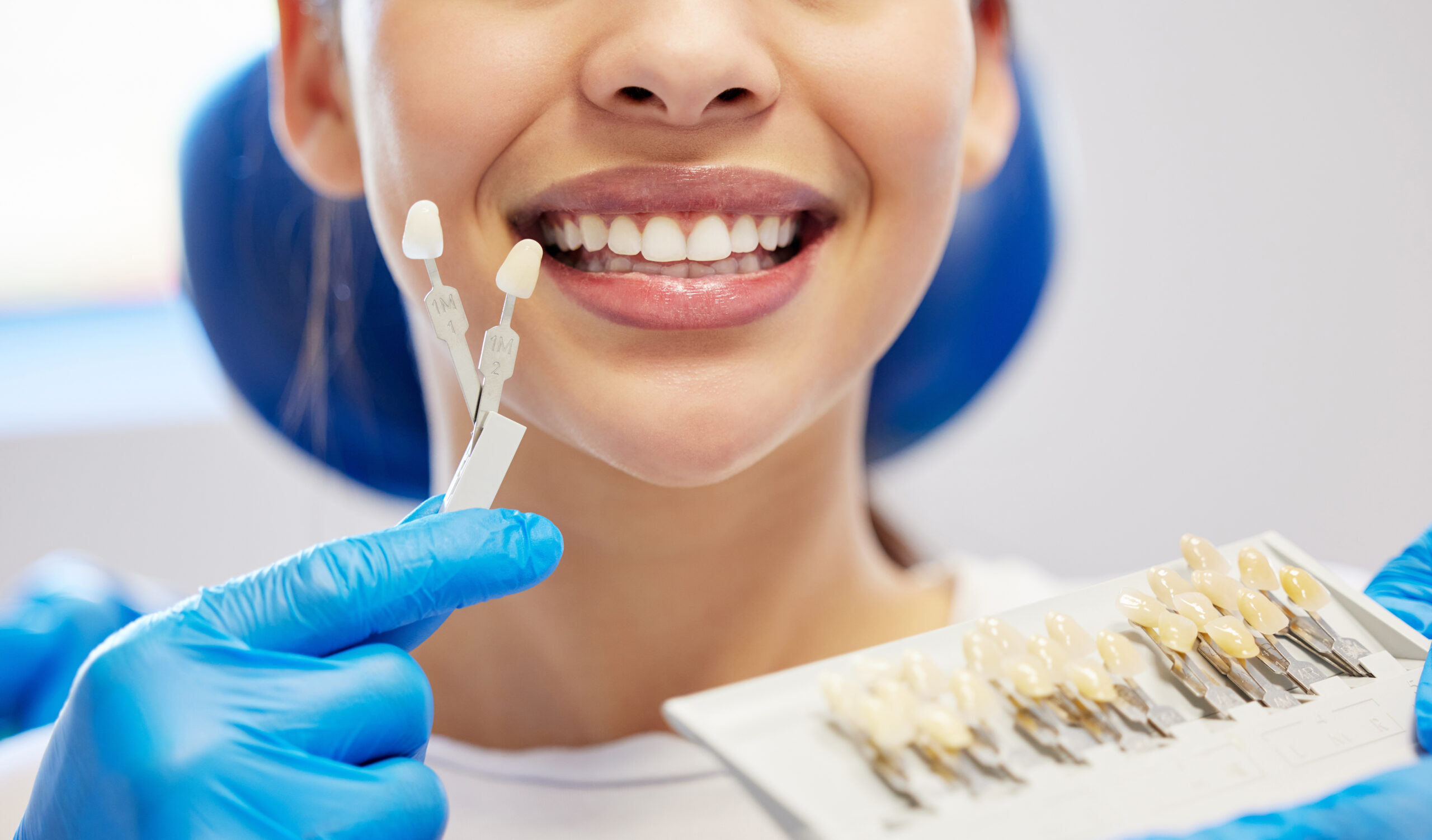 A girl holding up dental implants in a dentists chair