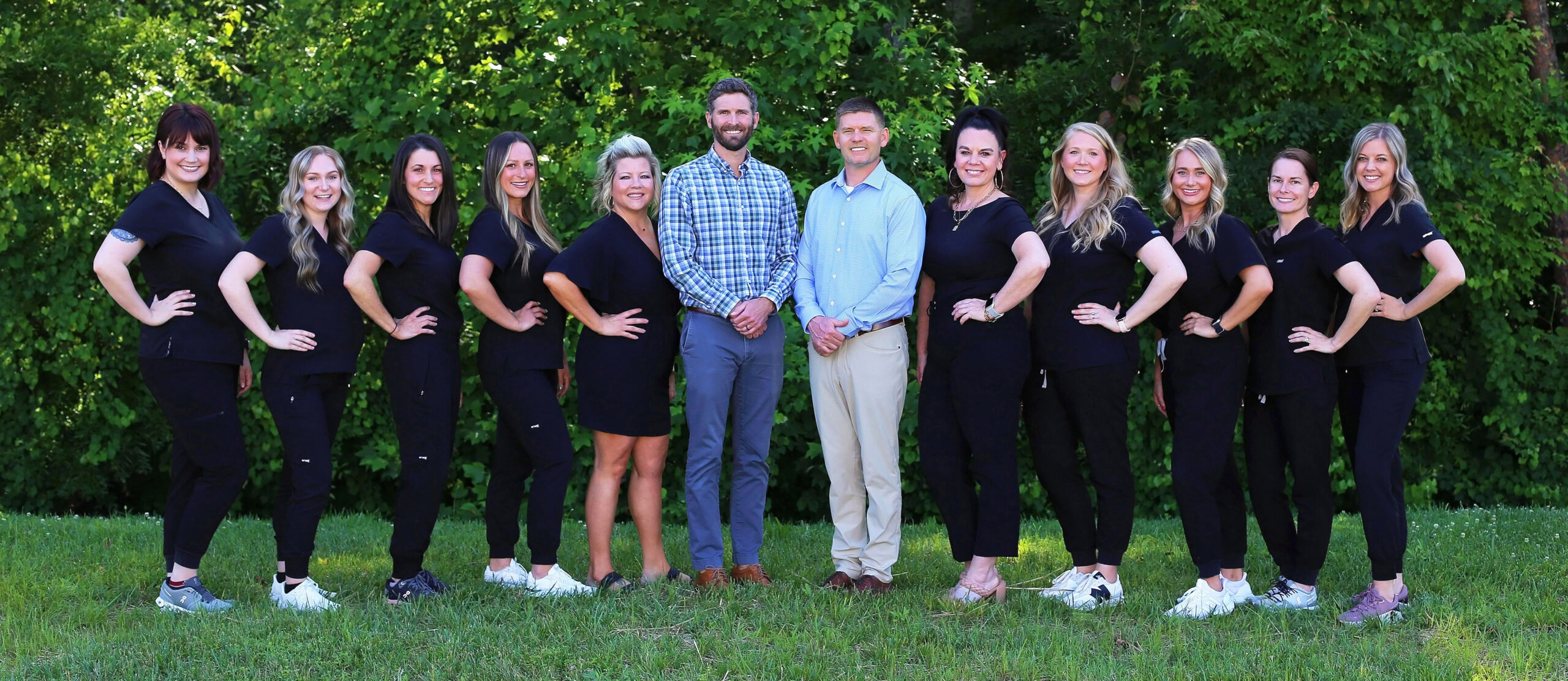 Photo of the Martin & Brune Dentistry Team standing outside in front of a tree line.